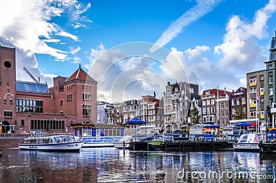 Tourist Canal Boats coming and going from the Damrak Canal in the old city center of Amsterdam Editorial Stock Photo