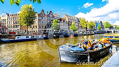 Tourist Canal Boats mooring at Anne Frank House at the Prinsengracht Prince Canal in the Jordaan neighborhood in Amsterdam Editorial Stock Photo