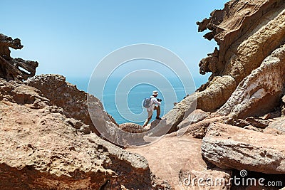 Tourist climbs the rock to make good shot of nature. Stock Photo