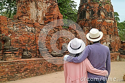 Tourist Couple Admiring a Group of Headless Buddha Images Remains in Wat Mahathat Ancient Temple in Ayutthaya, Thailand Stock Photo