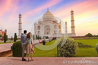 Tourist couple enjoy view of the Taj Mahal Agra at sunrise with moody sky Editorial Stock Photo