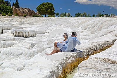 A tourist couple enjoying the natural beauty of the travertines and Pamukkale. Denizli-Turkey Editorial Stock Photo