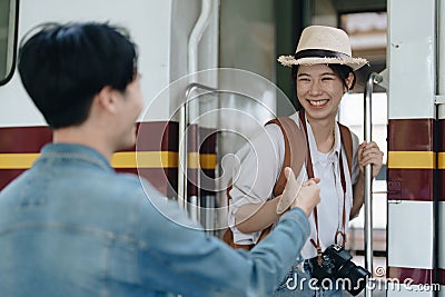 Tourist couples showing their love and happiness in a sweet way while waiting for their journey at the train station. Stock Photo