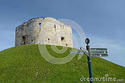 A tourist direction signpost by Cliffords's tower a stone monument in York UK Editorial Stock Photo