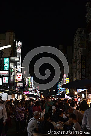 A tourist eating at the Liuhe night market in Kaohsiung Editorial Stock Photo