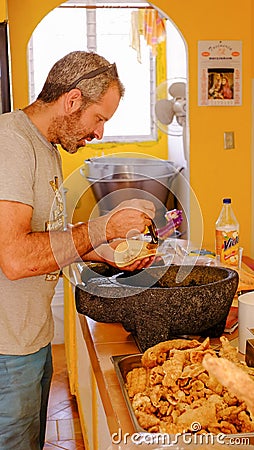 Tourist enjoys spicy Chicharron at mexican market in Aculco Editorial Stock Photo