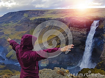 Tourist enjoying dramatic view of high waterfall in Iceland Stock Photo