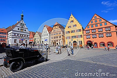 Tourist enjoying Markplatz with traditional houses and vintage car on the foreground in Rothenburg ob der Tauber Editorial Stock Photo