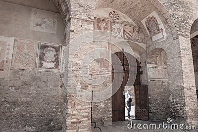 Tourist enters through large wooden doors into arched interior w Editorial Stock Photo