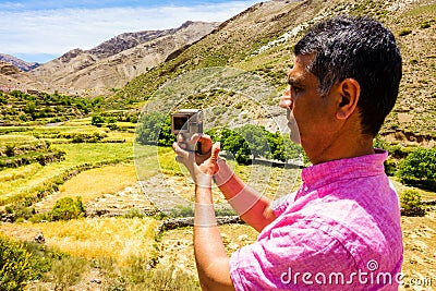 Tourist filming a Valley in the Atlas mountains Stock Photo