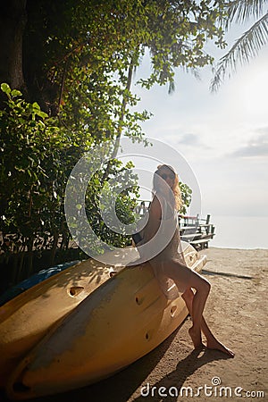 girl sitting on a boat at sunset Stock Photo