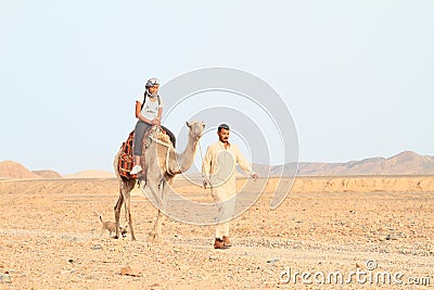 Tourist girl riding a camel Editorial Stock Photo