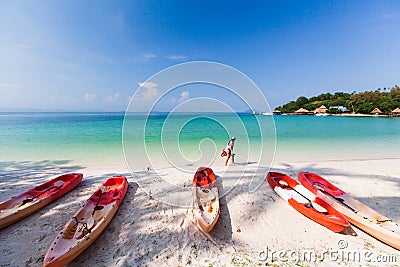 Tourist girl walks barefoot on the beach in summer Stock Photo