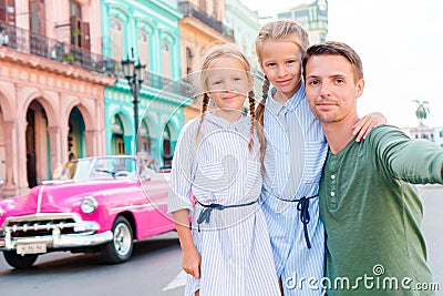Family in popular area in Old Havana, Cuba. Portrait of two kids and young dad outdoors on a street of Havana Stock Photo