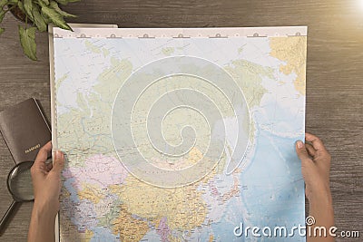 Tourist hand holding world map for planning vacation Stock Photo