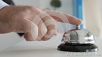 Tourist in Hotel Reception Presses the Bell Button Calling the Receptionist Stock Photo