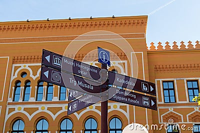 Tourist info sign with directions in front of old gymnasium in Mostar Editorial Stock Photo