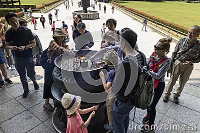 Tourist are lighting incense in front of hte Great Buddha Hall part of the buddhist Todai-ji temple Editorial Stock Photo