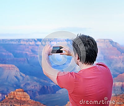 Tourist making mobile photo of the famous Grand Canyon Stock Photo