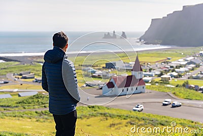 Tourist man enjoy looking view of Reyniskirkja church among the mountain on summer in Vik town Stock Photo