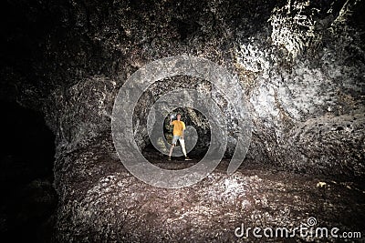 Tourist man explore the lava cave with flashlight in Maui, Hawaii. Stock Photo