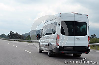 Tourist minibus in motion on background mountains Stock Photo