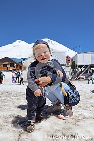 Tourist mother and little son on the snowy slope of mountain Elbrus in Russia Stock Photo