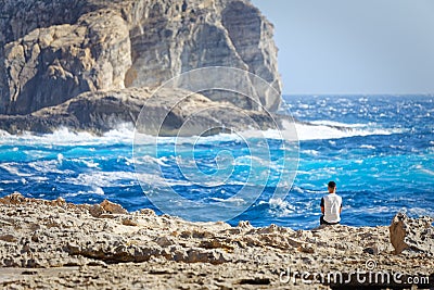 Tourist observe the rough seas of Dwejra Bay in Gozo, Malta Editorial Stock Photo