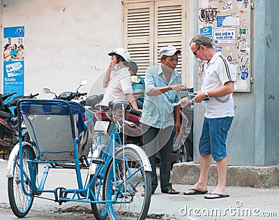 Tourist pays to Vietnamese cyclo driver Editorial Stock Photo