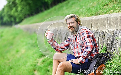 Tourist relaxing in park drink tea or coffee. Coffee on the go. man with a cup of coffee outdoors. Handsome calm bearded Stock Photo