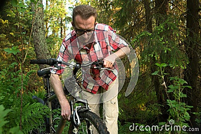 Tourist, repearing the bike in the woods Stock Photo