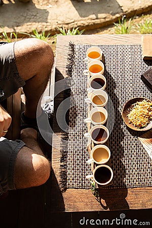 Tourist sat to taste different kinds of indonesian coffee at a touristic coffee plantation, Bali, Indonesia Stock Photo