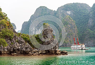 Tourist ship in the bay among the rocks in Halong bay, Vietnam. Stock Photo