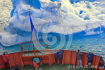 Tourist ship sails close to small iceberg Editorial Stock Photo