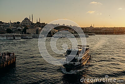 Tourist ship sails on the Golden Horn, scenic sunny beautiful waterfront of Istanbul city at sunset in summer Editorial Stock Photo