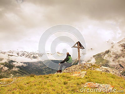 Tourist stand on rocky view point and watching into misty Alpine valley. W Stock Photo