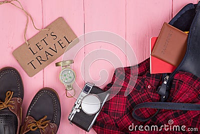 Tourist stuff - bag, passport, camera, compass, shoes, shirt, note pad and blackboard with text Let's travel Stock Photo