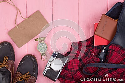 Tourist stuff - bag, passport, camera, compass, shoes, shirt, note pad and blank blackboard on wooden background Stock Photo