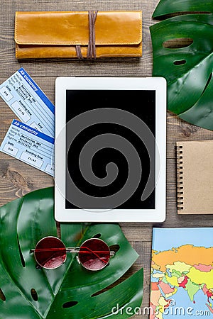 Tourist stuff with map and tablet on wooden background top view Stock Photo