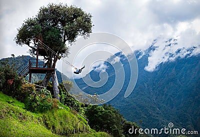 Tourist swinging on the swing of the end of the world Columpio del fin del mundo in BaÃ±os, Ambato province, Ecuador. Stock Photo