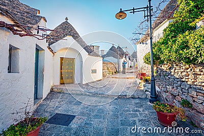 Tourist take picture of strret with trullo trulli - traditional Apulian dry stone hut with a conical roof. Splendid spring city Stock Photo