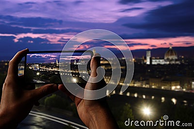 Tourist taking photo of Florence after sunset from Michelangelo square, Florence, Italy. Beautiful panoramic view of Duomo Santa Stock Photo