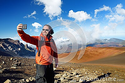 Tourist taking a photo of himself in Haleakala volcano crater on the Sliding Sands trail, Maui, Hawaii Stock Photo