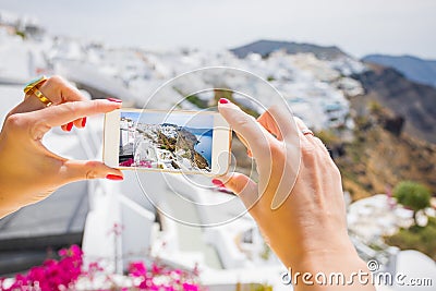 Tourist taking picture of Santorini with mobile phone Stock Photo