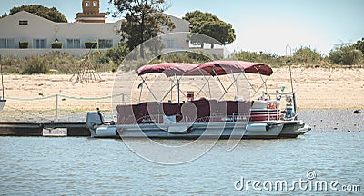 Tourist transport boats moored in the lagoons of the Ria Formosa Natural Park near the port of Tavira, portugal Editorial Stock Photo