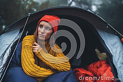 Tourist traveler ralaxing in camp tent in froggy rain forest, hiker woman enjoy mist nature trip, green trekking tourism, rest Stock Photo