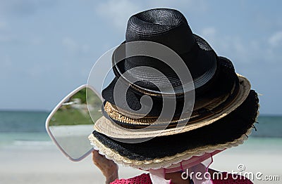 Tourist trying on Bahama hats. Stock Photo