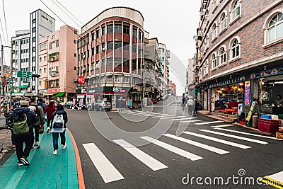 Tourist walks in Yehliu fisherman village downtown area with road, crosswalk and buildings in northern Taipei Editorial Stock Photo