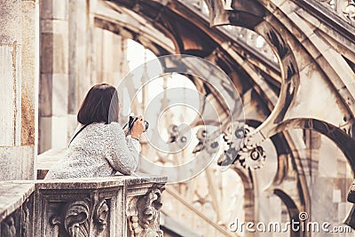 Tourist woman with camera on the Milan Cathedral roof Stock Photo