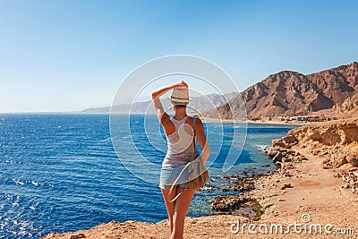 Tourist woman in Dahab near Blue Hole at the Red Sea coast. Famous travel destionation in desert. Sharm el Sheik, Dahab, Sinai Stock Photo
